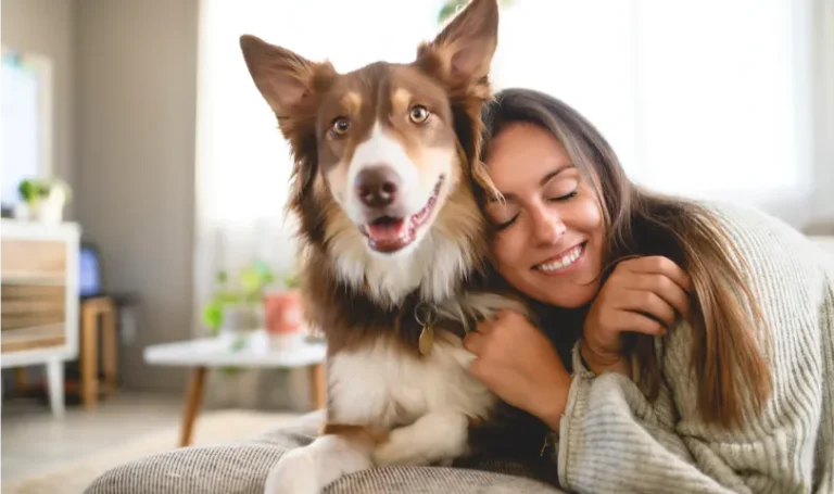A woman smiling next to her dog.